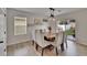 Elegant dining room with modern lighting fixture and backyard view through sliding glass door at 11019 Leland Groves Dr, Riverview, FL 33579