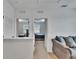 Bright hallway that leads to two bedrooms and a common area featuring neutral walls, plush carpeting, and a comfortable sofa at 11019 Leland Groves Dr, Riverview, FL 33579