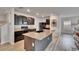 Modern kitchen featuring dark cabinets, granite countertops, and a large island sink at 11019 Leland Groves Dr, Riverview, FL 33579