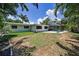 Large backyard with lush greenery, a patio, a screened-in lanai, and outdoor seating for relaxation at 112 Peterson Ln, Palm Harbor, FL 34683