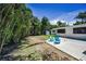 A backyard oasis features a patio with chairs, lush landscaping, and a tranquil outdoor setting at 112 Peterson Ln, Palm Harbor, FL 34683
