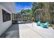 Secluded backyard with a screened patio, concrete area, and lush bamboo, ideal for entertaining at 112 Peterson Ln, Palm Harbor, FL 34683