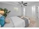 Bright bedroom with neutral colors, ceiling fan, and access to the bathroom and closets at 112 Peterson Ln, Palm Harbor, FL 34683