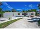 Single story home featuring an expansive driveway and well-maintained landscaping at 112 Peterson Ln, Palm Harbor, FL 34683