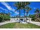 Beautiful home exterior with lush tropical landscaping and a circular driveway at 112 Peterson Ln, Palm Harbor, FL 34683