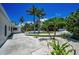 Well-manicured front yard featuring palm trees, white gravel, and a spacious concrete driveway at 112 Peterson Ln, Palm Harbor, FL 34683