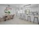 Bright kitchen and dining area featuring a quartz countertop bar, modern lighting, and tiled floors at 112 Peterson Ln, Palm Harbor, FL 34683