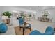 Open living space with blue chairs, dining area, and neutral sofas, perfect for entertaining at 112 Peterson Ln, Palm Harbor, FL 34683