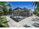 A screened-in patio with landscaping around the perimeter, providing an ideal outdoor living space at 112 Peterson Ln, Palm Harbor, FL 34683