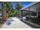 Enclosed patio with screened-in walls featuring outdoor seating and lush tropical landscaping at 112 Peterson Ln, Palm Harbor, FL 34683