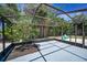 A screened-in patio with gravel landscaping and view to the backyard at 112 Peterson Ln, Palm Harbor, FL 34683