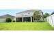 Well-manicured backyard with a screened lanai, a grassy lawn, a sturdy white fence, and some lovely palm trees at 11408 Scribner Station Ln, Lithia, FL 33547