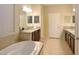 Bright bathroom features double vanities, a soaking tub, and tile flooring at 11408 Scribner Station Ln, Lithia, FL 33547