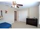 Bedroom featuring a ceiling fan, double door closet, and a warm neutral color palette at 11408 Scribner Station Ln, Lithia, FL 33547