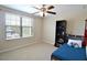 Bedroom featuring a ceiling fan, window overlooking the front yard, and a cozy area rug at 11408 Scribner Station Ln, Lithia, FL 33547