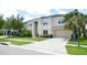 Tan two-story home with a two-car garage, mature landscaping, and a long driveway at 11408 Scribner Station Ln, Lithia, FL 33547