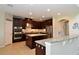 Modern kitchen with an island, stainless steel appliances, and dark wood cabinets at 11408 Scribner Station Ln, Lithia, FL 33547