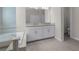 Bathroom featuring a double vanity, with tile flooring, a soaking tub and a walk-in shower at 11881 Ranchers Gap Dr, Odessa, FL 33556