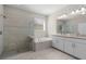 Bright bathroom with a glass shower, soaking tub, double vanity, and neutral tiling at 11881 Ranchers Gap Dr, Odessa, FL 33556