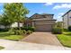 Inviting two-story home with a well-maintained lawn, brick driveway, and attached two-car garage at 11881 Ranchers Gap Dr, Odessa, FL 33556