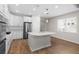 Kitchen featuring an island, stainless appliances, white cabinetry, and wood-look flooring at 11881 Ranchers Gap Dr, Odessa, FL 33556