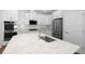 Bright kitchen featuring white cabinets, stainless appliances, and an island with marbled countertops at 11881 Ranchers Gap Dr, Odessa, FL 33556