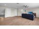 Spacious living room with wood-look floors, a ceiling fan, and a TV at 11881 Ranchers Gap Dr, Odessa, FL 33556