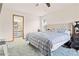 Primary bedroom with carpet, a blue striped bedspread, neutral headboard, and an attached bathroom at 12546 Brookside St, Spring Hill, FL 34609