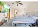 Primary bedroom with carpet, a blue striped bedspread, neutral headboard, television and an attached bathroom at 12546 Brookside St, Spring Hill, FL 34609