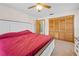 Spacious bedroom with a ceiling fan, large window, and closet with wood paneled sliding doors at 12546 Brookside St, Spring Hill, FL 34609