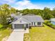 Aerial view of a one-story home with a screened-in garage and a well manicured green lawn at 12546 Brookside St, Spring Hill, FL 34609