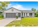Charming single-story home with a well-maintained lawn, screened garage door, and classic design details at 12546 Brookside St, Spring Hill, FL 34609