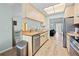 Well-lit kitchen with light wood cabinets, stainless steel dishwasher, and a view into the living area at 12546 Brookside St, Spring Hill, FL 34609