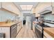 Kitchen with stainless steel appliances, wooden cabinetry, and wood laminate flooring throughout at 12546 Brookside St, Spring Hill, FL 34609