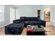 Living room featuring a black, plush sectional sofa, modern coffee table, and wood laminate flooring at 12546 Brookside St, Spring Hill, FL 34609