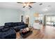 Bright living room featuring a ceiling fan, modern furniture, and sliding doors to the outdoor area at 12546 Brookside St, Spring Hill, FL 34609