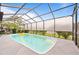 Covered in-ground pool surrounded by lush landscaping offers ultimate privacy and relaxation at 12546 Brookside St, Spring Hill, FL 34609
