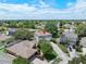 Aerial view features a charming home with a spacious yard, surrounded by mature trees and well-kept neighboring houses at 1291 Blackrush Dr, Tarpon Springs, FL 34689