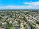 Wide aerial shot capturing a tranquil neighborhood with tree-covered homes and a distant view of the horizon at 1291 Blackrush Dr, Tarpon Springs, FL 34689