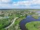 Expansive aerial view showcasing a community nestled amidst lush greenery and waterways under a bright, cloudy sky at 1291 Blackrush Dr, Tarpon Springs, FL 34689