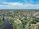 Wide-angle aerial showcases a residential area with winding streets, water access, and a mix of homes surrounded by trees at 1291 Blackrush Dr, Tarpon Springs, FL 34689