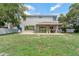 Spacious backyard with a covered patio and lush green grass, perfect for outdoor entertaining and relaxation at 1291 Blackrush Dr, Tarpon Springs, FL 34689