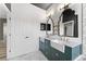 Bathroom with double sinks, stylish mirrors, marble counter tops, and modern fixtures at 1291 Blackrush Dr, Tarpon Springs, FL 34689