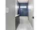 Elegant bathroom with a modern vanity, stylish blue tile, and marble-patterned floors at 1291 Blackrush Dr, Tarpon Springs, FL 34689