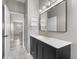 Tasteful bathroom featuring a dark vanity with gold fixtures and hexagon tile floors at 1291 Blackrush Dr, Tarpon Springs, FL 34689
