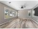 Bright bedroom featuring wood-look flooring, neutral paint, and shuttered windows at 1291 Blackrush Dr, Tarpon Springs, FL 34689