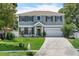 Charming two-story home featuring a well-maintained lawn, a green front door, and an attached two-car garage at 1291 Blackrush Dr, Tarpon Springs, FL 34689