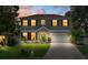Twilight view of a two-story home with a well-manicured lawn, illuminated windows, and inviting curb appeal at 1291 Blackrush Dr, Tarpon Springs, FL 34689