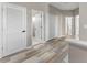 Bright hallway with wood-look flooring, multiple doors, and white trim at 1291 Blackrush Dr, Tarpon Springs, FL 34689