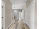 Neutral hallway with wood-look flooring, white doors, and ample closet space at 1291 Blackrush Dr, Tarpon Springs, FL 34689